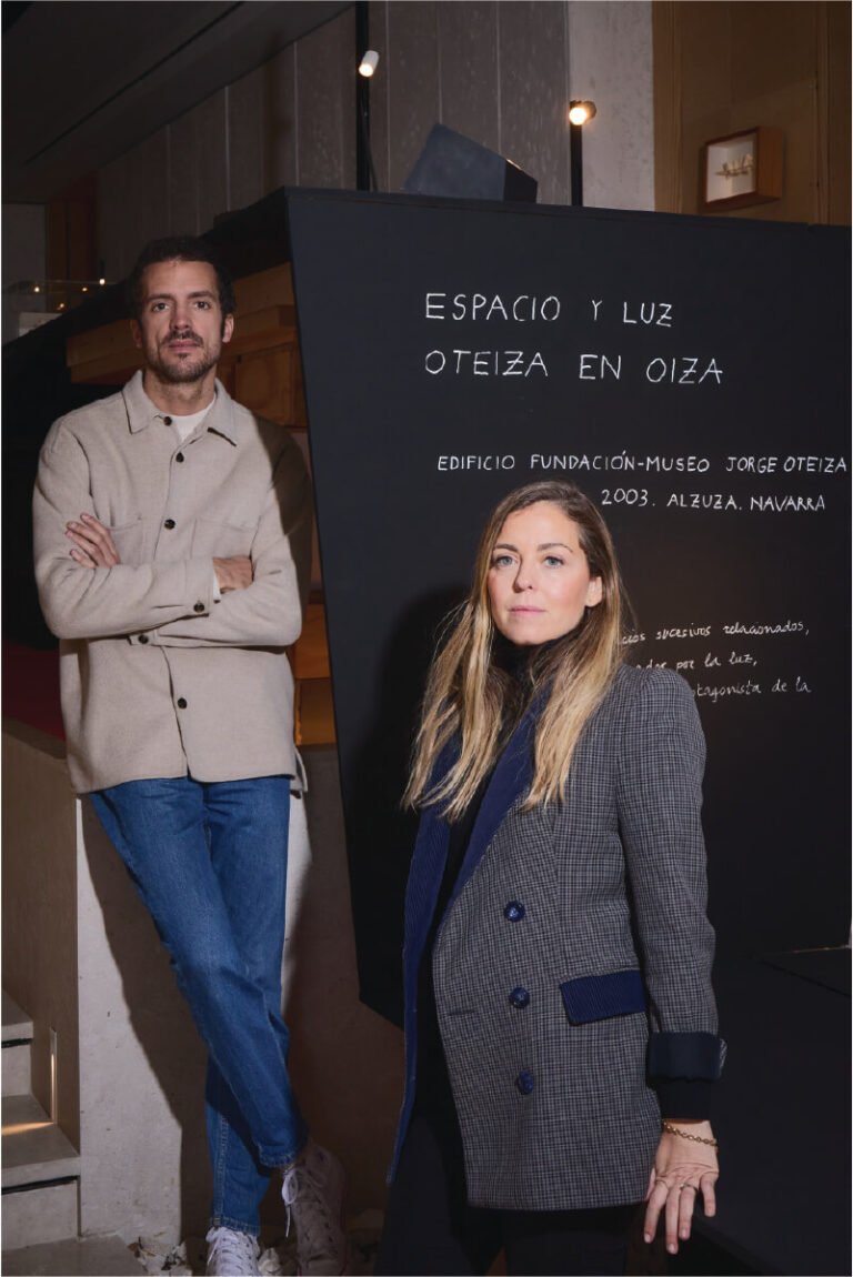 Raquel y Nacho, socios fundadores de POLIGHT, posando frente a la exposición 