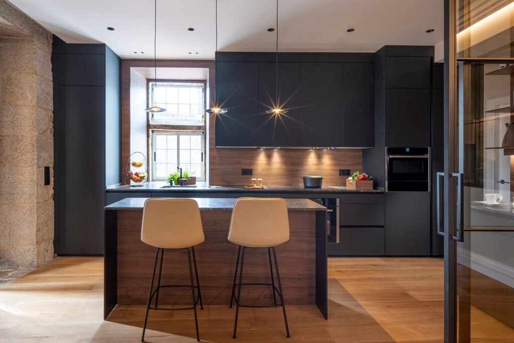 Cocina moderna con iluminación cálida sobre la encimera y en el techo, creando un ambiente acogedor